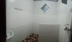 a white bathroom with a toilet and a sink at Volcano 3 hotel in Kintamani