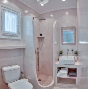 a bathroom with a shower and a toilet and a sink at Glaros Studios Apartments in Antiparos +113 photos