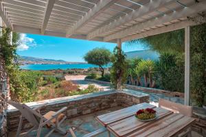 a patio with a table and chairs and a view of the water at Glaros Studios Apartments in Antiparos
