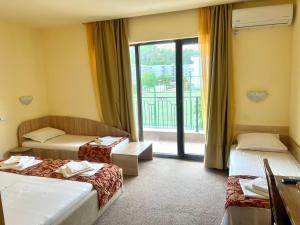 a hotel room with two beds and a window at Maria Garden in Kranevo +16 photos