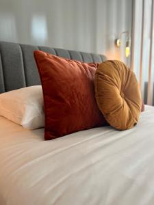 a brown pillow sitting on top of a bed at Le Penhoët, Hyper centre de Rennes in Rennes