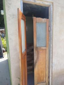Una puerta abierta a una habitación con un marco de puerta y una puerta. en Quarto Pérola simples, en Gonçalves