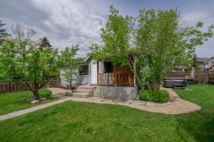 een tuin met een huis met een patio en bomen bij Family Playhouse in Calgary