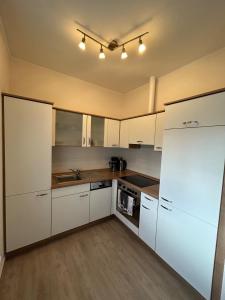 a kitchen with white cabinets and a white refrigerator at Ferienhaus Seeidylle in Geeste