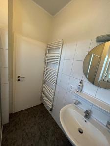 a bathroom with a sink and a mirror and a door at Ferienhaus Seeidylle in Geeste