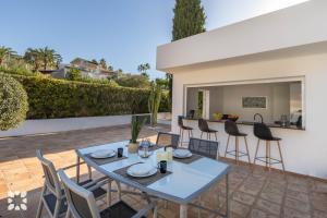 a patio with a blue table and chairs at Villa La Morena by Abahana Villas in Fanadix