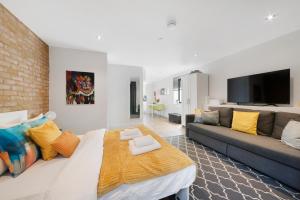 a living room with a large bed and a couch at Manor House Studios By Morethanstays in London
