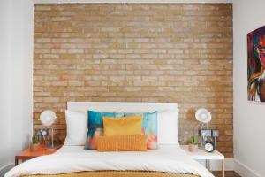 a bedroom with a brick wall and a bed at Manor House Studios By Morethanstays in London