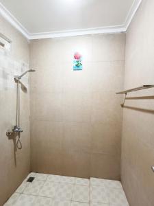 baño con ducha y suelo de baldosa. en YUTAKA LG Dukuh Kupang, en Surabaya