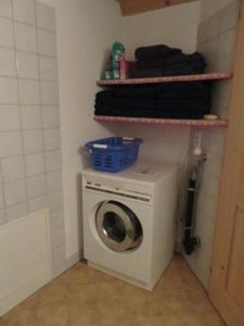 y baño pequeño con lavadora y secadora. en Ferienwohnung Howart - b48611 en Ebnat