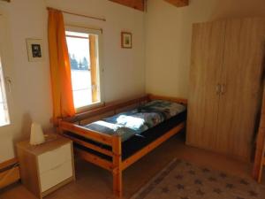 1 dormitorio con cama de madera y ventana en Ferienwohnung Howart - b48611 en Ebnat