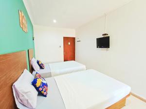 Zimmer mit 2 Betten und einem TV an der Wand in der Unterkunft YUTAKA LG Dukuh Kupang in Surabaya