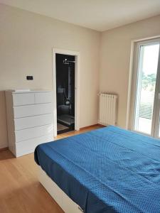 una camera bianca con un letto blu e un comò di B&Bob Private Apartment in Bari a Bari