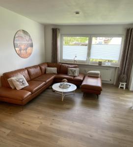 uma sala de estar com um sofá de couro castanho e uma mesa em Winterberg Appartement 21116 em Winterberg