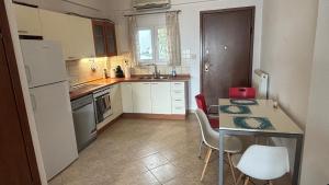 a small kitchen with a table and a refrigerator at Petro's House in Nikiti
