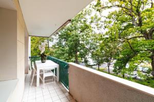 balcón con mesa, sillas y árboles en Appartement moderne près de Genève, en Ferney-Voltaire