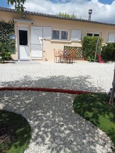 a house with a red hose in front of it at une pause quelque part au jardin des érables et des niwakis in Saint-Médard-de-Guizières