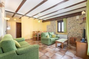 sala de estar con sofá verde y sillas en Apartamento Casa El Cojo 2b, en Alcalá de la Selva