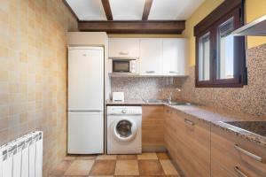 cocina con nevera blanca y lavadora en Apartamento Casa El Cojo 2b, en Alcalá de la Selva