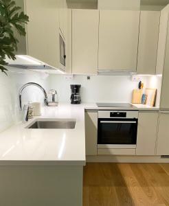 ヘルシンキにあるModern apartment in a prime locationの白いキャビネットとシンク付きのキッチン