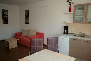 ein Wohnzimmer mit einem roten Sofa und einer Küche in der Unterkunft Fineda Grande Apartments in Poreč