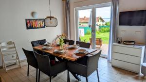 a dining room with a table and chairs and a television at Haus Linda in Plau am See