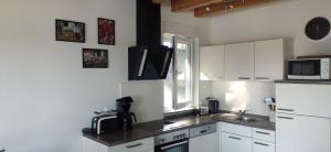 a kitchen with white cabinets and a sink and a microwave at Haus Linda in Plau am See