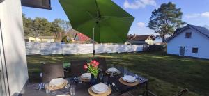 a table with a green umbrella in a yard at Haus Linda in Plau am See