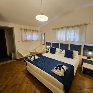 Albis Rooms Guest House في فيوميتشينو: غرفة نوم بسرير كبير وملاءات زرقاء وبيضاء