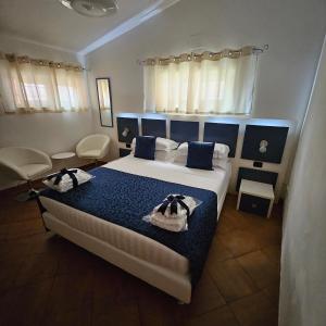 1 dormitorio con 1 cama con 2 toallas en Albis Rooms Guest House, en Fiumicino