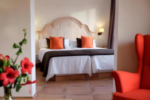 1 dormitorio con cama con almohadas de color naranja y silla roja en Bakour Fuerteventura La Pared, en La Pared