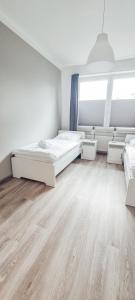1 Schlafzimmer mit 2 Betten und Holzboden in der Unterkunft Zweibettzimmer "Grau" in zentraler Lage in Bremen