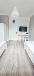 ein Wohnzimmer mit Holzboden und einem Tisch in der Unterkunft Zweibettzimmer "Grau" in zentraler Lage in Bremen