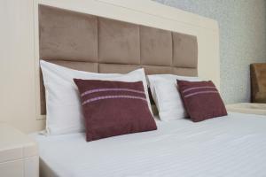 una camera con un letto con due cuscini sopra di Safran Hotel a Baku