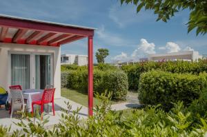 eine Terrasse mit einem Tisch, Stühlen und Büschen in der Unterkunft Vada Village in Vada