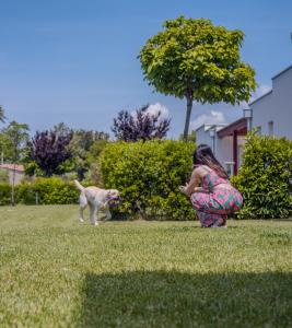 Une jeune fille jouant avec un chien dans l'herbe dans l'établissement Vada Village, à Vada