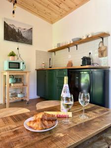 una cocina con una mesa con un plato de pan y copas de vino en Domek nad Zegrzem en Arciechow