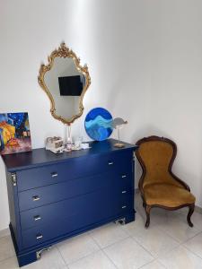 uma cómoda azul com um espelho e uma cadeira em Petite Etoile em SantʼAgata di Militello