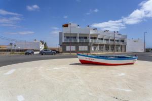 a boat sitting on the ground in front of a building at Somar in Puerto de las Lajas