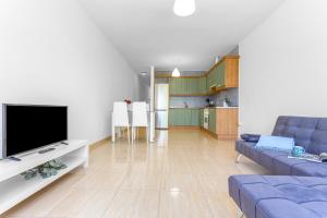 a living room with a couch and a tv at Somar in Puerto de las Lajas