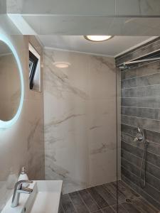 uma casa de banho com um chuveiro e um lavatório. em Marina Sarafovo em Burgas