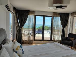 sypialnia z łóżkiem i widokiem na ocean w obiekcie Marina Sarafovo w Burgas