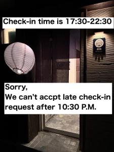 una señal que dice que la hora de registro es y una ventana en 328 Hostel & Lounge, en Tokio