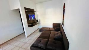 a living room with a couch and a tv at Casa Jardim Colorado in Vila Velha