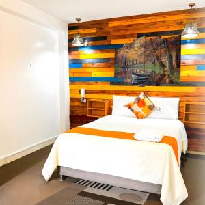 Ayacucho Plaza في اياكوتشو: غرفة نوم مع سرير وبجدار لكنة خشبية
