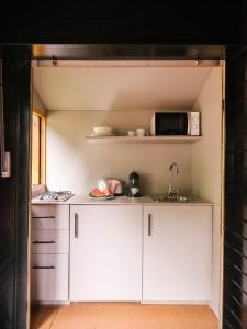 a kitchen with white cabinets and a microwave at wecamp Cudillero in El Pito