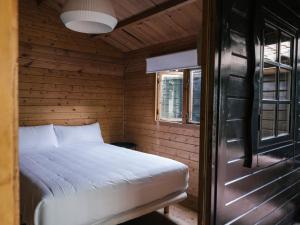 a bed in a wooden cabin with a window at wecamp Cudillero in El Pito
