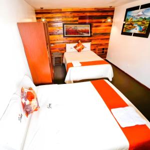 Habitación de hotel con 2 camas y pared de madera. en Ayacucho Plaza en Ayacucho