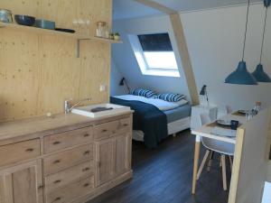 ein Badezimmer mit einem Waschbecken und ein Schlafzimmer mit einem Bett in der Unterkunft B&B Zonnedael in Oosterend