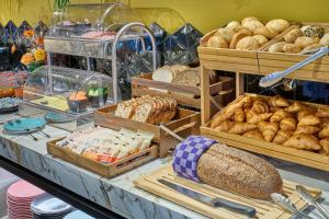 uma padaria com muitos tipos diferentes de pão em Hotel Restaurant Grandcafé 't Voorhuys em Emmeloord
